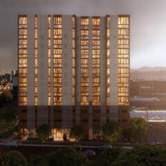 a beautiful12-story building made of mass timber set against a Denver sunset